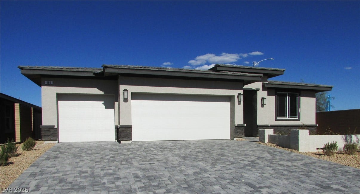 988 Gentle Swan, Henderson, NV 89011 A contemporary single-story residence presents a paved driveway leading to two garage doors.