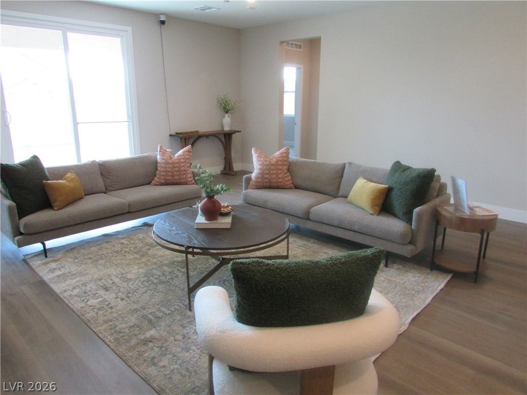 988 Gentle Swan, Henderson, NV 89011 A well-lit living area with ample space for entertaining, featuring smooth flooring and access to outdoor areas. Photo is of actual home.