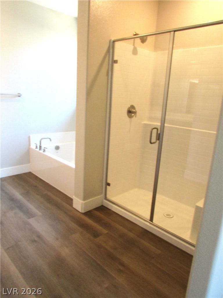 988 Gentle Swan, Henderson, NV 89011 A well-appointed bathroom features both a glass-enclosed shower and a separate soaking tub, creating a private retreat. Photo is of actual home.