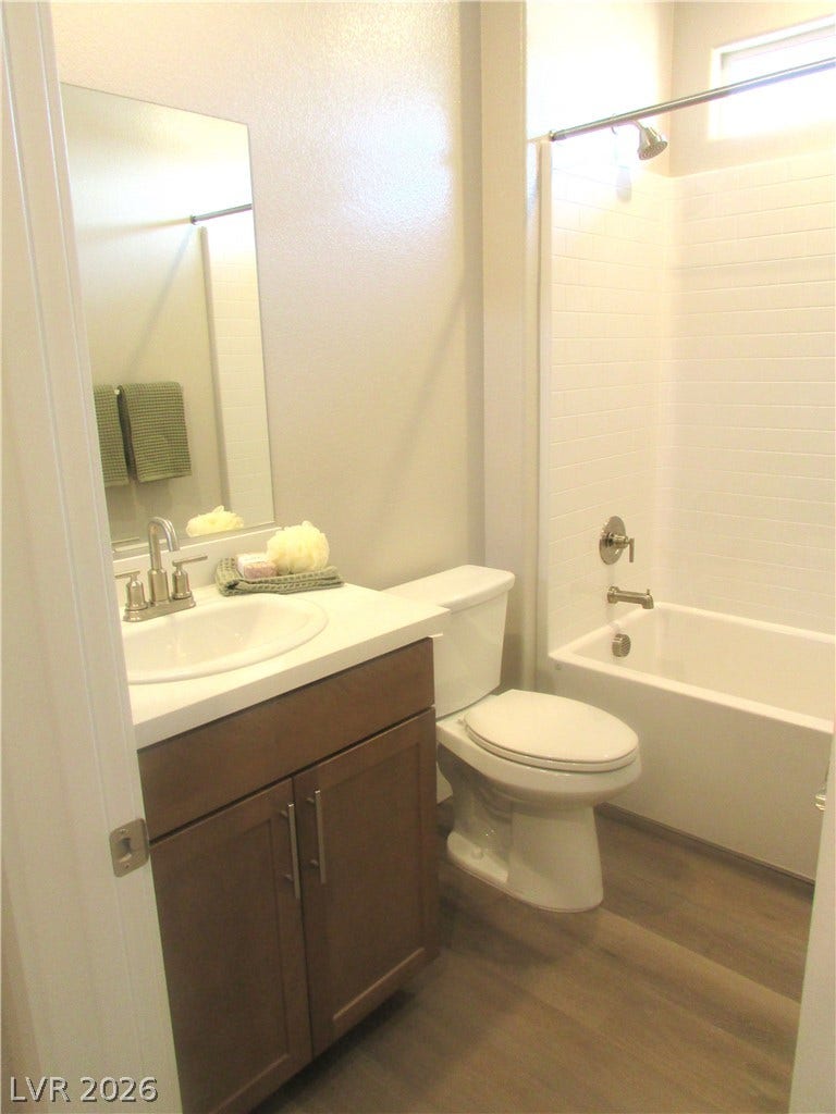 988 Gentle Swan, Henderson, NV 89011 A well-appointed bathroom features wood-toned cabinetry, crisp white countertops, and a full bath. Photo is of actual home.
