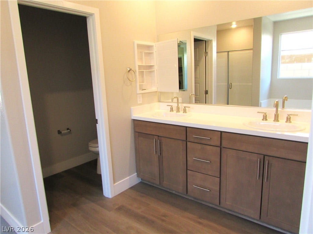 988 Gentle Swan, Henderson, NV 89011 A well-appointed primary bathroom featuring a double vanity and sleek modern finishes. Photo is of actual home.