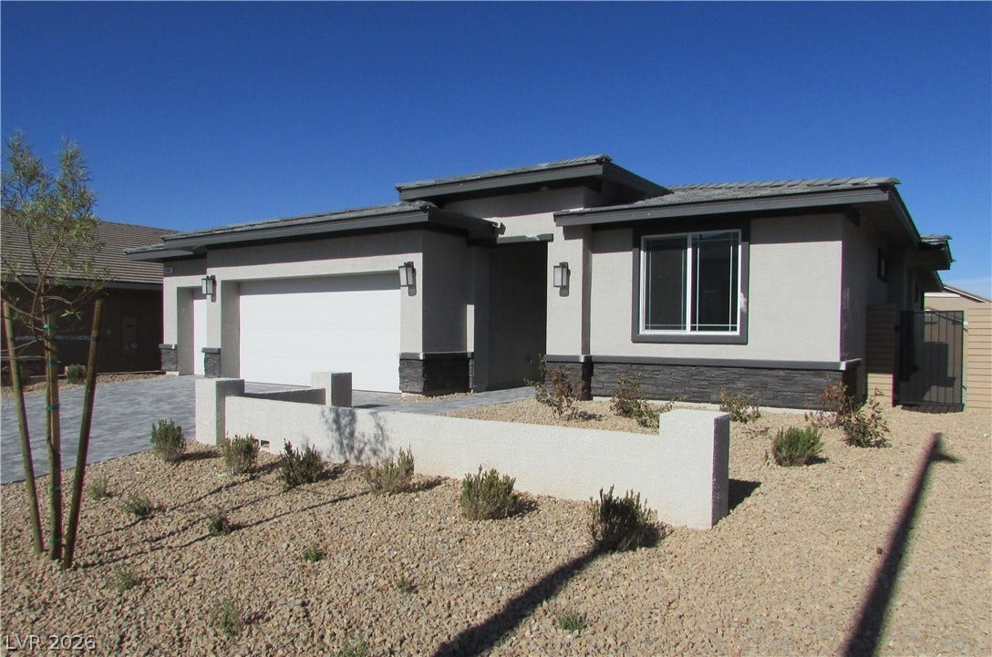 988 Gentle Swan, Henderson, NV 89011 A modern stucco home with a two-car garage features xeriscape landscaping.