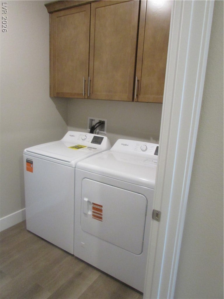 988 Gentle Swan, Henderson, NV 89011 Functional laundry space featuring stacked appliances and convenient overhead cabinetry.