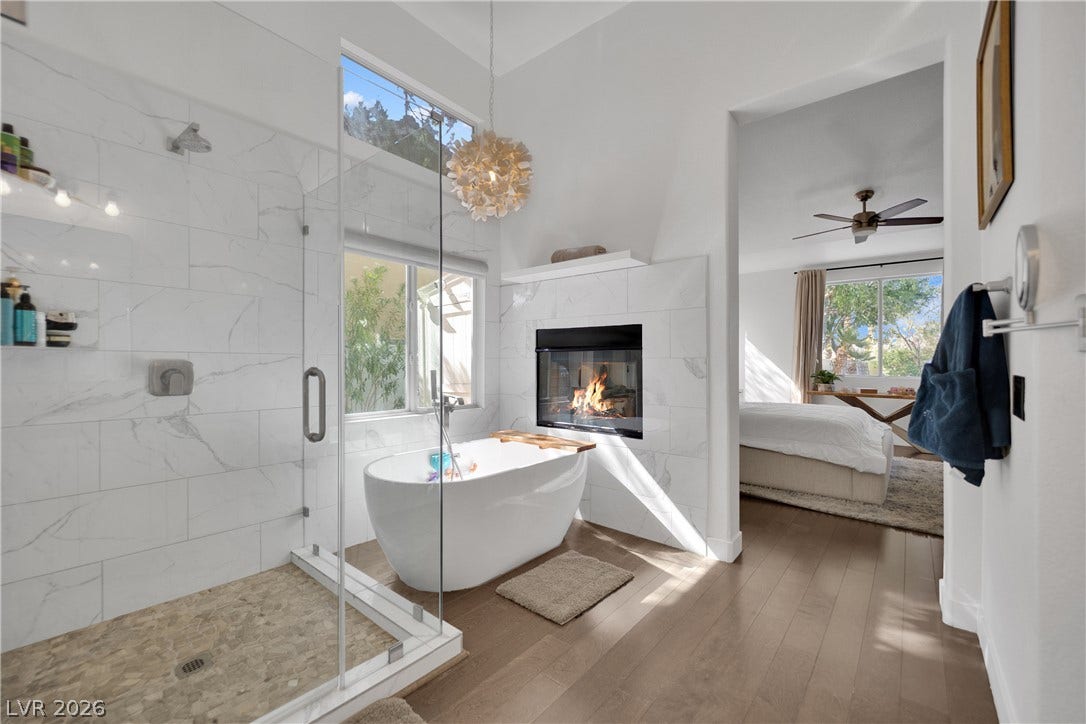 2516 Serenity Hollow Drive, Henderson, NV 89052 Indulge in a spa-like retreat with this elegant primary bathroom, featuring a freestanding soaking tub and a cozy 2-way fireplace.