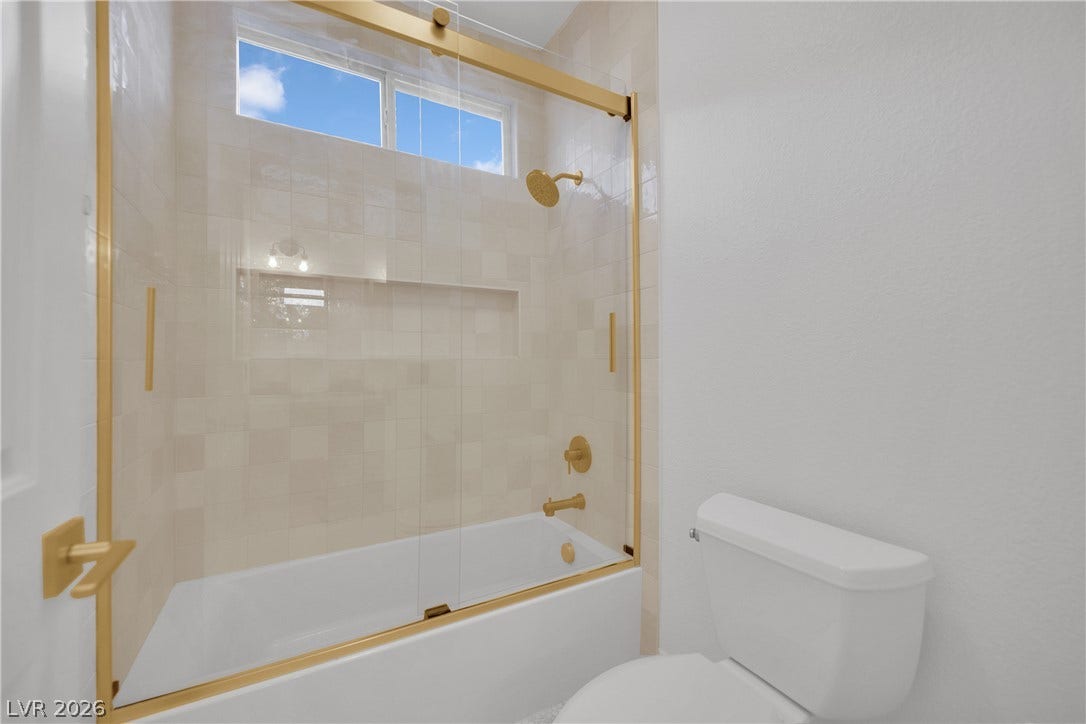 2516 Serenity Hollow Drive, Henderson, NV 89052 A sleek, contemporary tub-shower combination features clear glass doors with elegant gold-toned hardware.