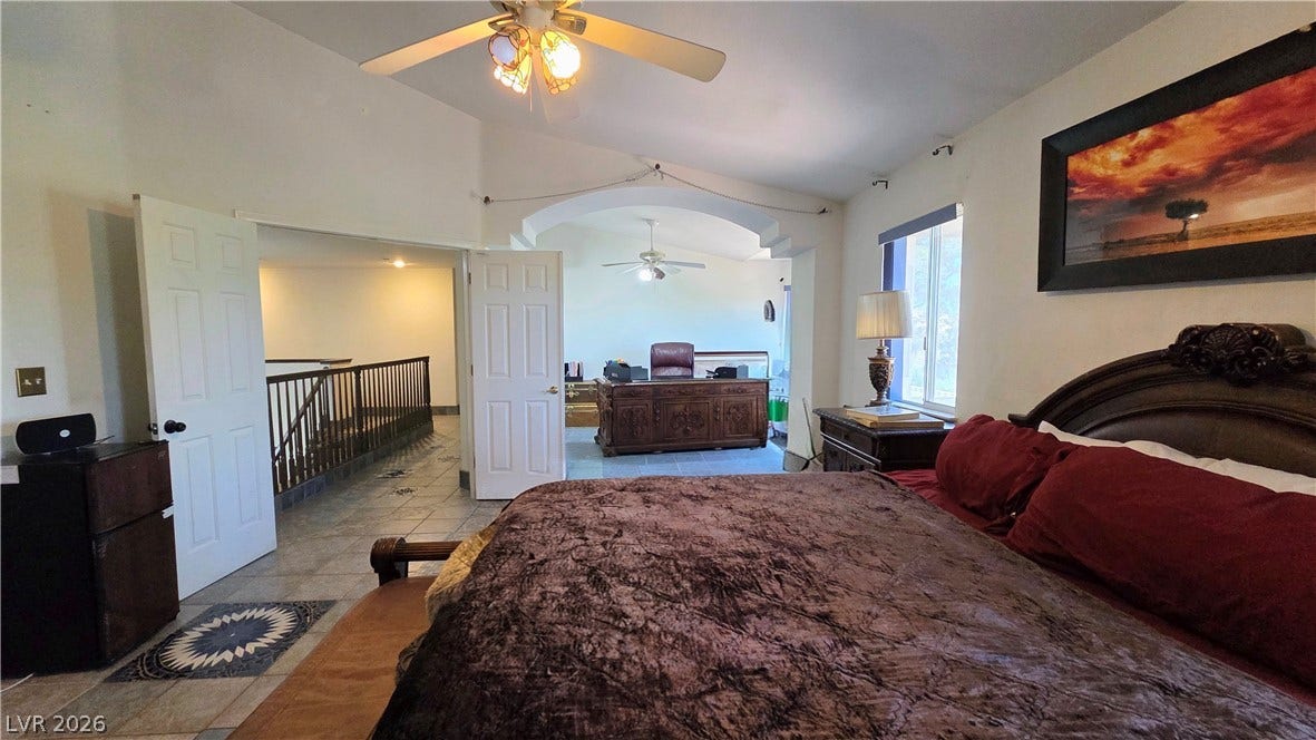 884 E Robindale Road, Las Vegas, NV 89123 Lofty ceilings crown this primary bedroom, offering an adjoining office space and a view to the open hallway below.