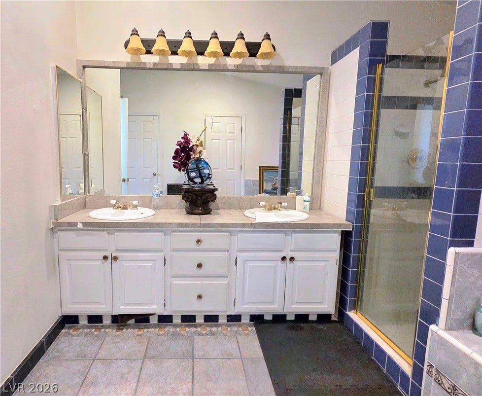 884 E Robindale Road, Las Vegas, NV 89123 Double vanity with ample counter space and a sleek, tiled shower enclosure.