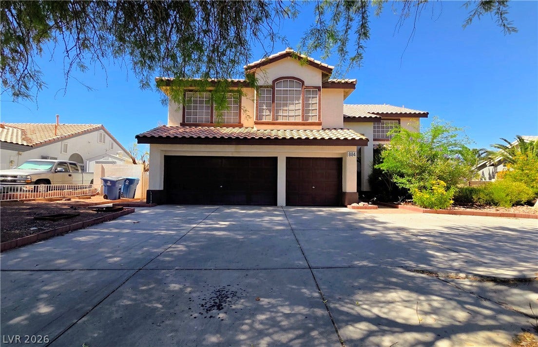 884 E Robindale Road, Las Vegas, NV 89123 A well-maintained facade with a two-car garage and a paved driveway awaits.
