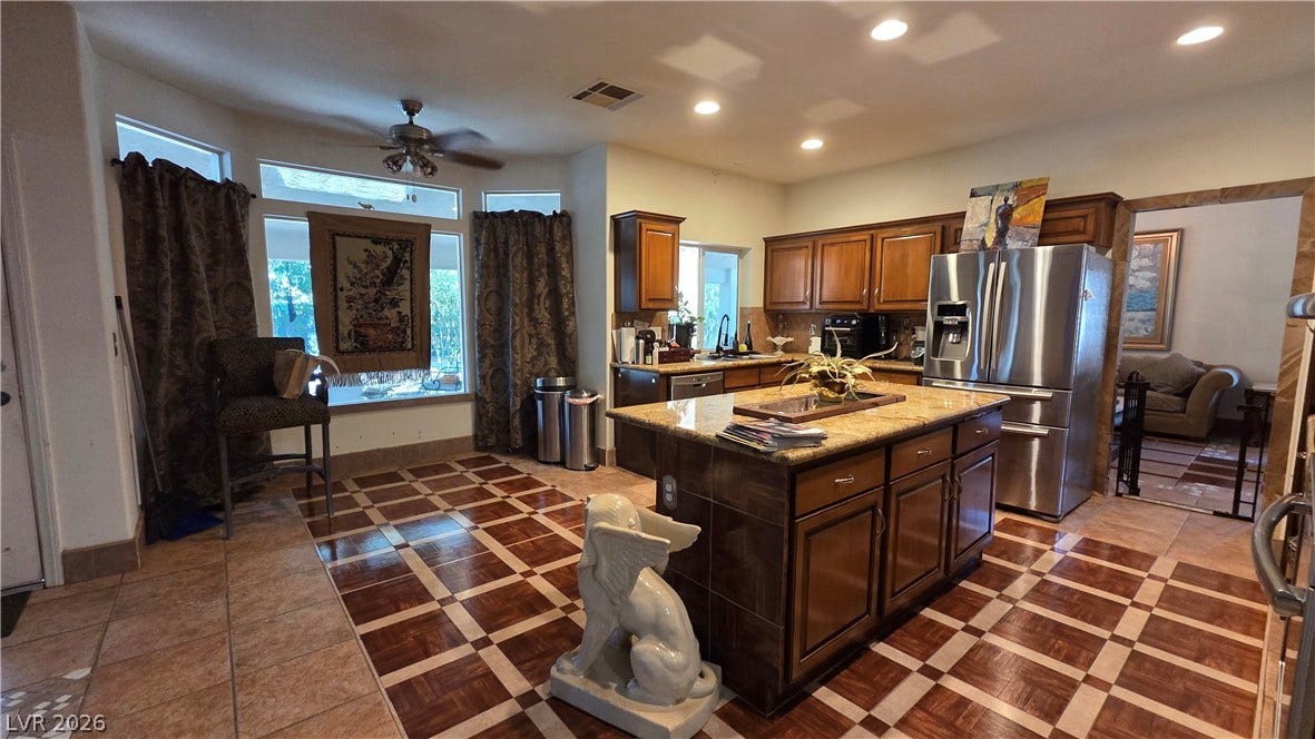 884 E Robindale Road, Las Vegas, NV 89123 A spacious culinary haven features a grand central island, ample cabinet storage, and contemporary stainless steel appliances.