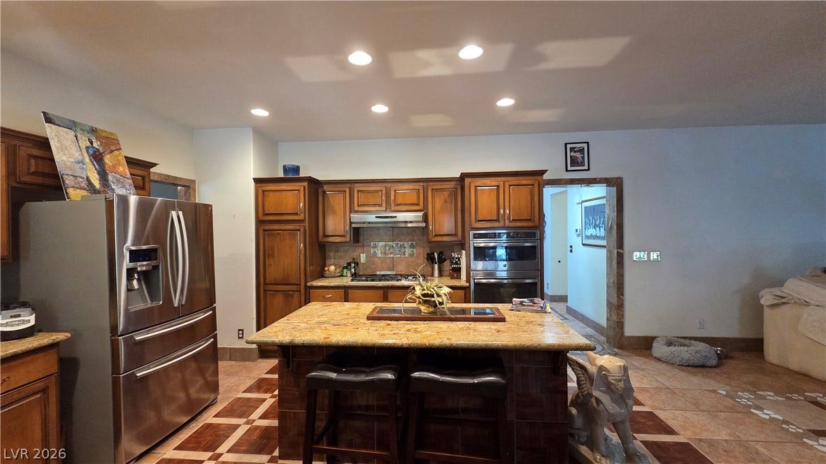 884 E Robindale Road, Las Vegas, NV 89123 Culinary delights await in this chef's kitchen featuring ample cabinetry and a grand central island.
