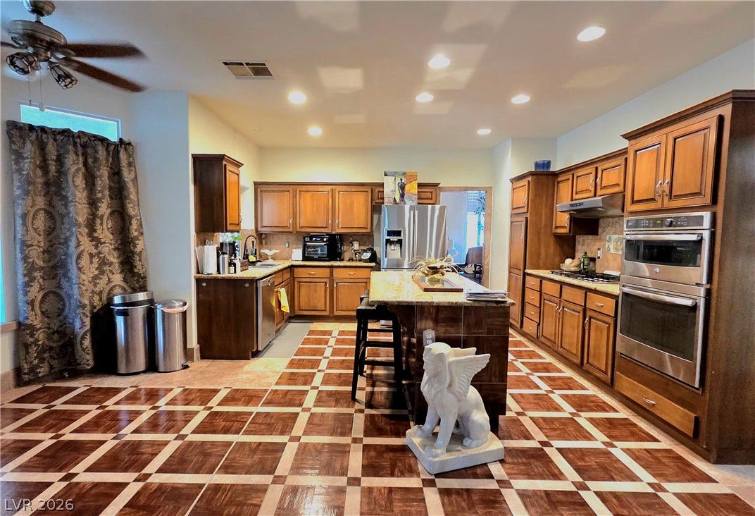 884 E Robindale Road, Las Vegas, NV 89123 A well-appointed culinary space featuring ample wood cabinetry and modern stainless-steel appliances.