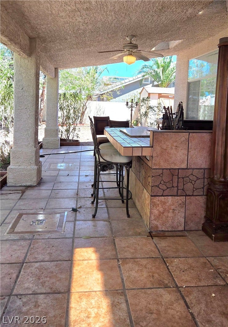 884 E Robindale Road, Las Vegas, NV 89123 An inviting covered patio features a built-in outdoor kitchen with tiled counters and a ceiling fan for al fresco dining. Built-in BBQ.