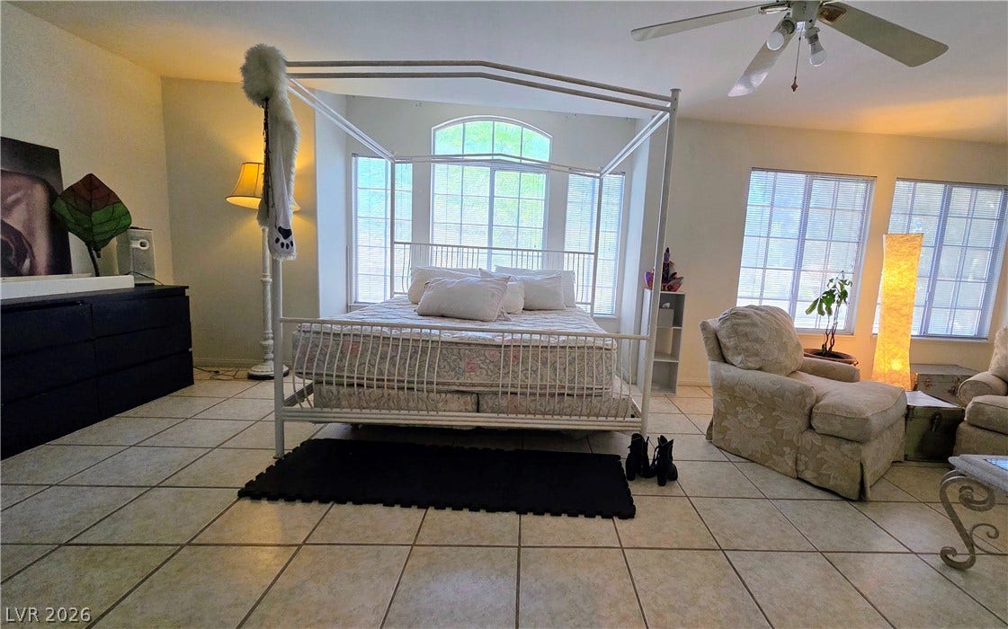 884 E Robindale Road, Las Vegas, NV 89123 The generously sized bedroom boasts abundant natural light, enhanced by wide bay windows and practical tiled flooring.