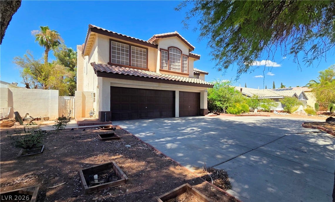 884 E Robindale Road, Las Vegas, NV 89123 A classic two-story home with a spacious concrete driveway and dual garage doors awaits.