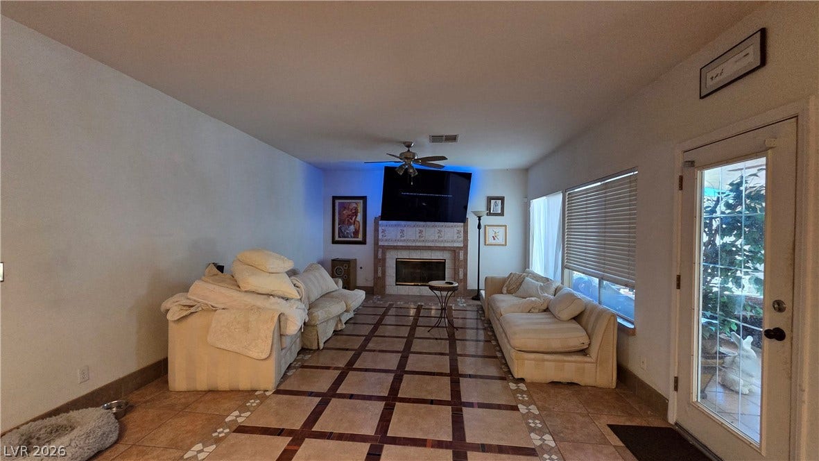 884 E Robindale Road, Las Vegas, NV 89123 A large living area featuring a fireplace and tiled floors, perfect for relaxing.