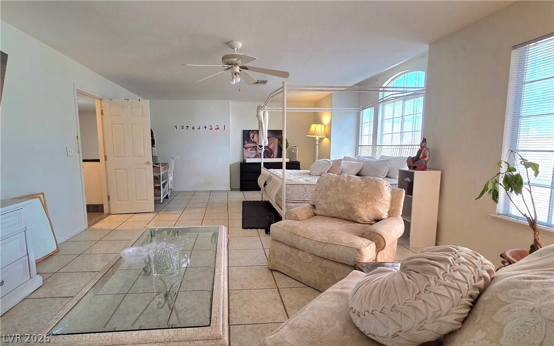 884 E Robindale Road, Las Vegas, NV 89123 Natural light floods this spacious primary bedroom, offering ample room for comfort and relaxation.