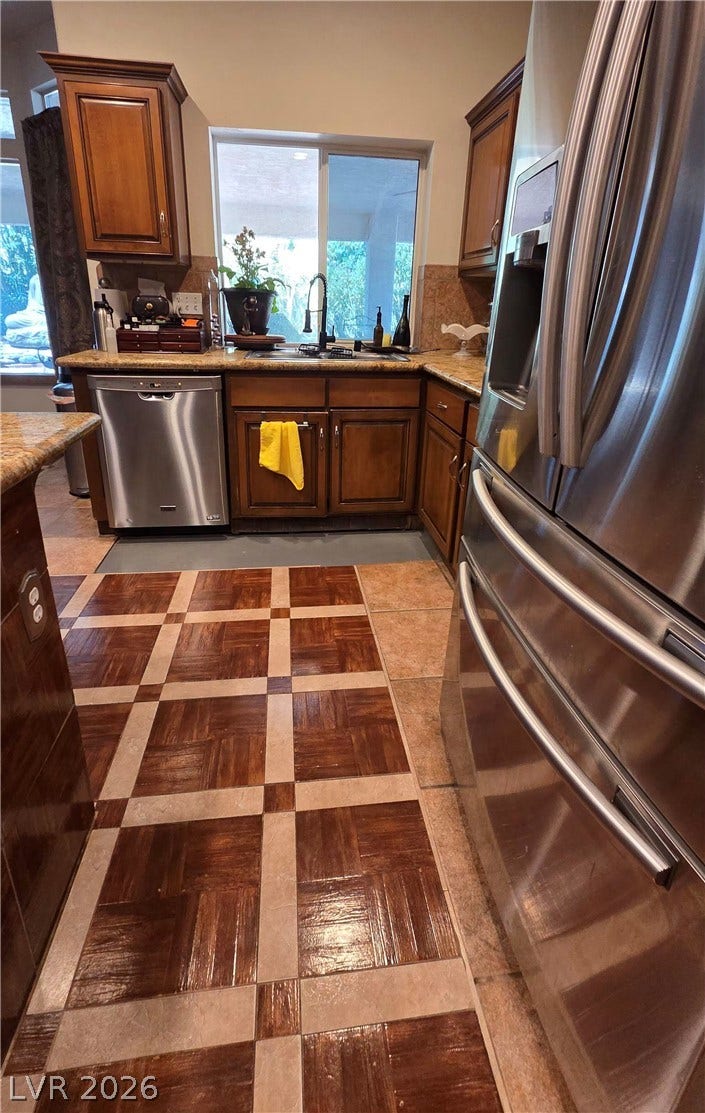 884 E Robindale Road, Las Vegas, NV 89123 A well-appointed kitchen showcasing elegant granite counters and integrated stainless steel appliances.