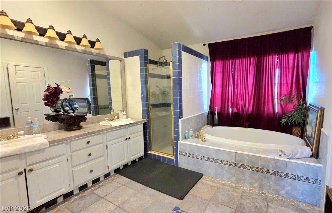 884 E Robindale Road, Las Vegas, NV 89123 A well-appointed primary bathroom showcases dual vanities, a luxurious soaking tub, and a separate shower.