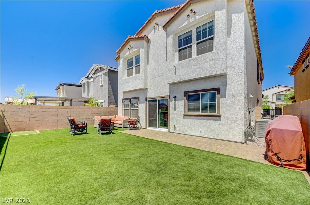 A private yard with artificial turf offers comfortable outdoor living and space for recreation.