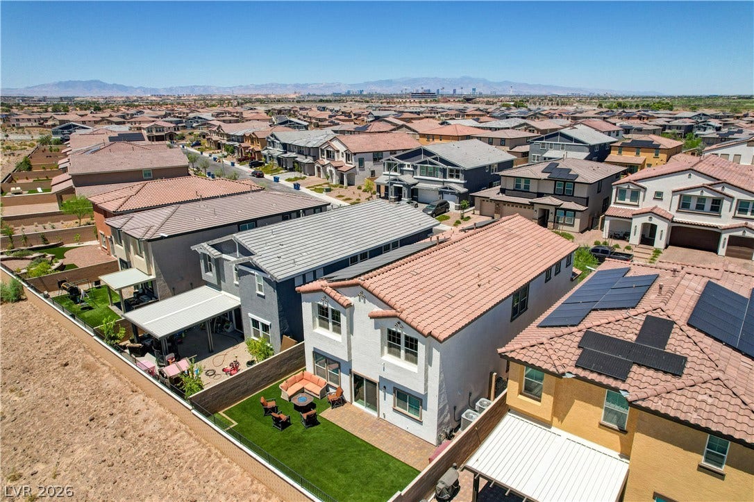 An aerial perspective reveals a vibrant neighborhood under a clear sky, showcasing a variety of homes.