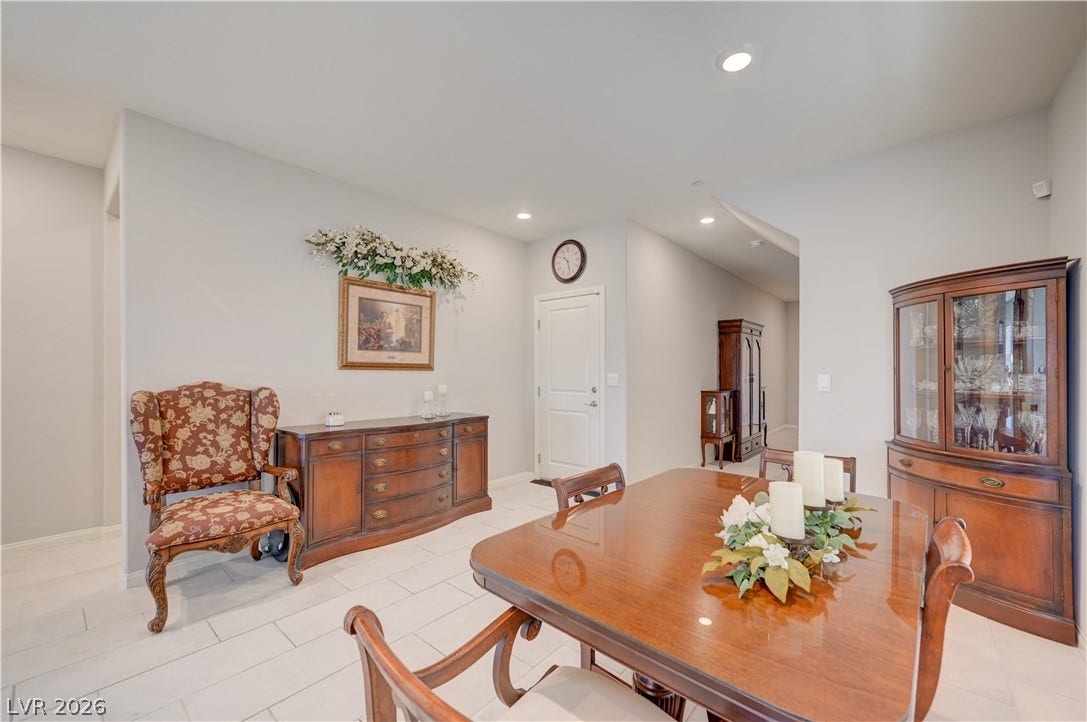 Recessed lighting illuminates this inviting formal dining room, featuring sleek tiled flooring and ample space for entertaining.