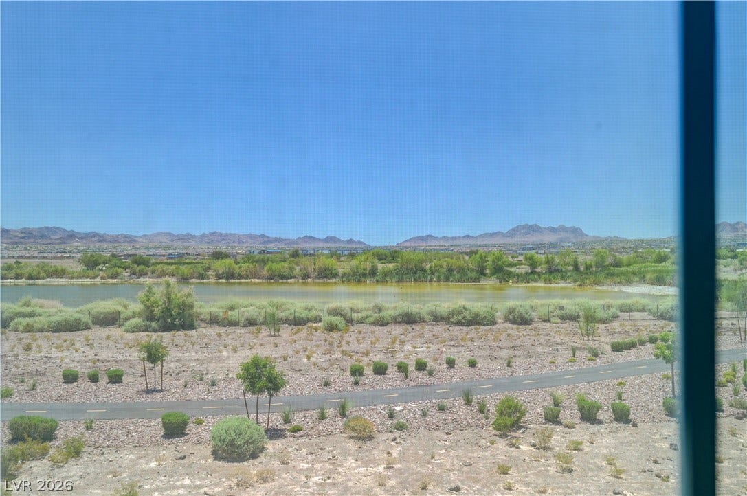 A tranquil Henderson bird preserve unfolds with distant mountains under a vast, clear sky.