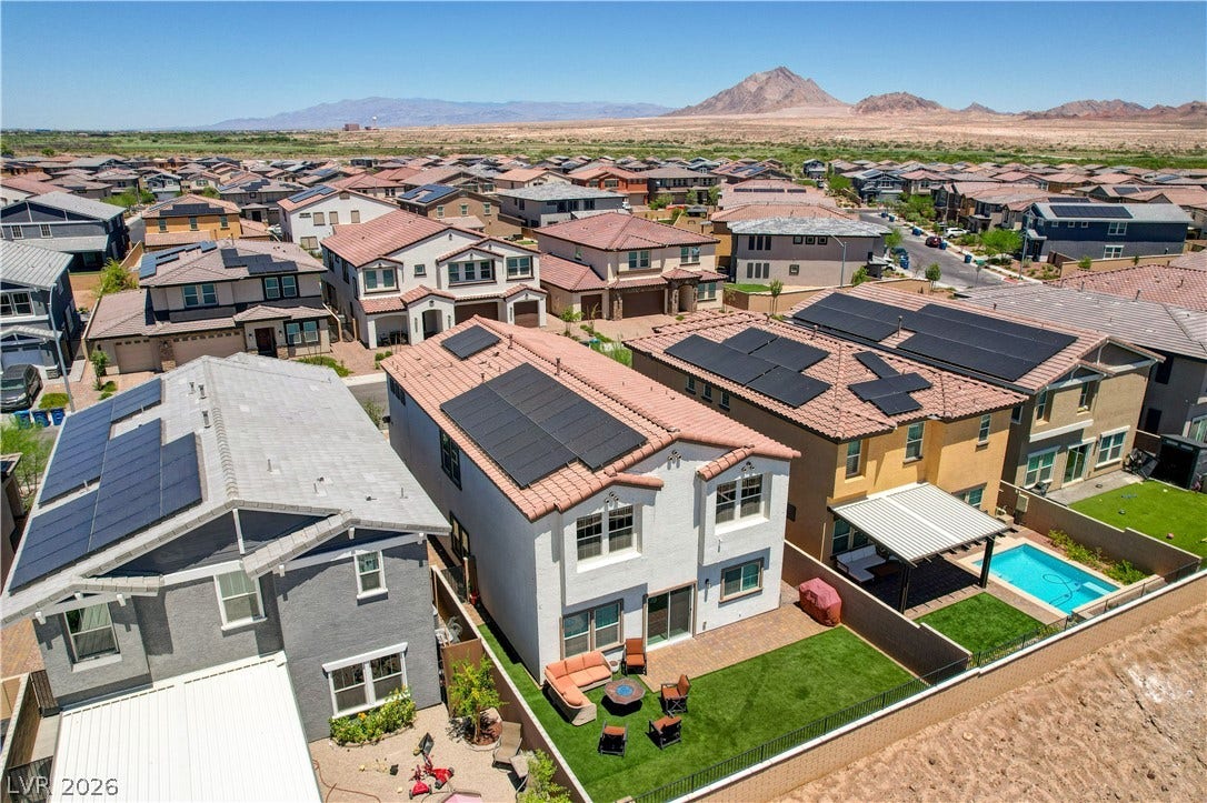 An aerial perspective reveals a vibrant neighborhood with mountain views and residential solar panels.