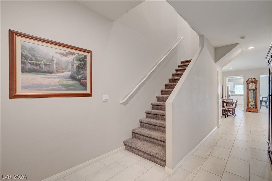 A graceful staircase with soft carpeting invites ascent within this well-lit entryway.