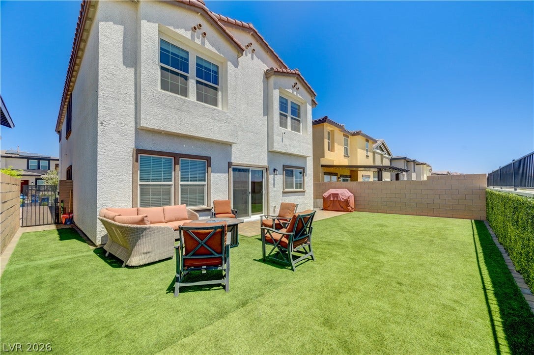 A private backyard oasis with low-maintenance artificial turf and ample patio space for outdoor enjoyment.