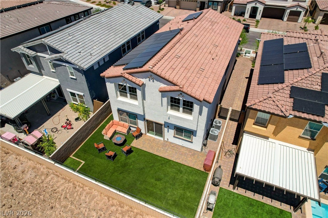 A well-maintained yard with artificial turf and a cozy patio area invites outdoor relaxation.