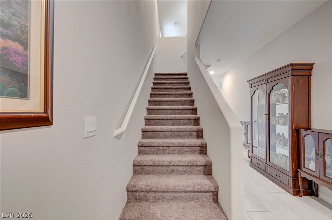 Carpeted stairs ascend to an upper level, offering a quiet transition.