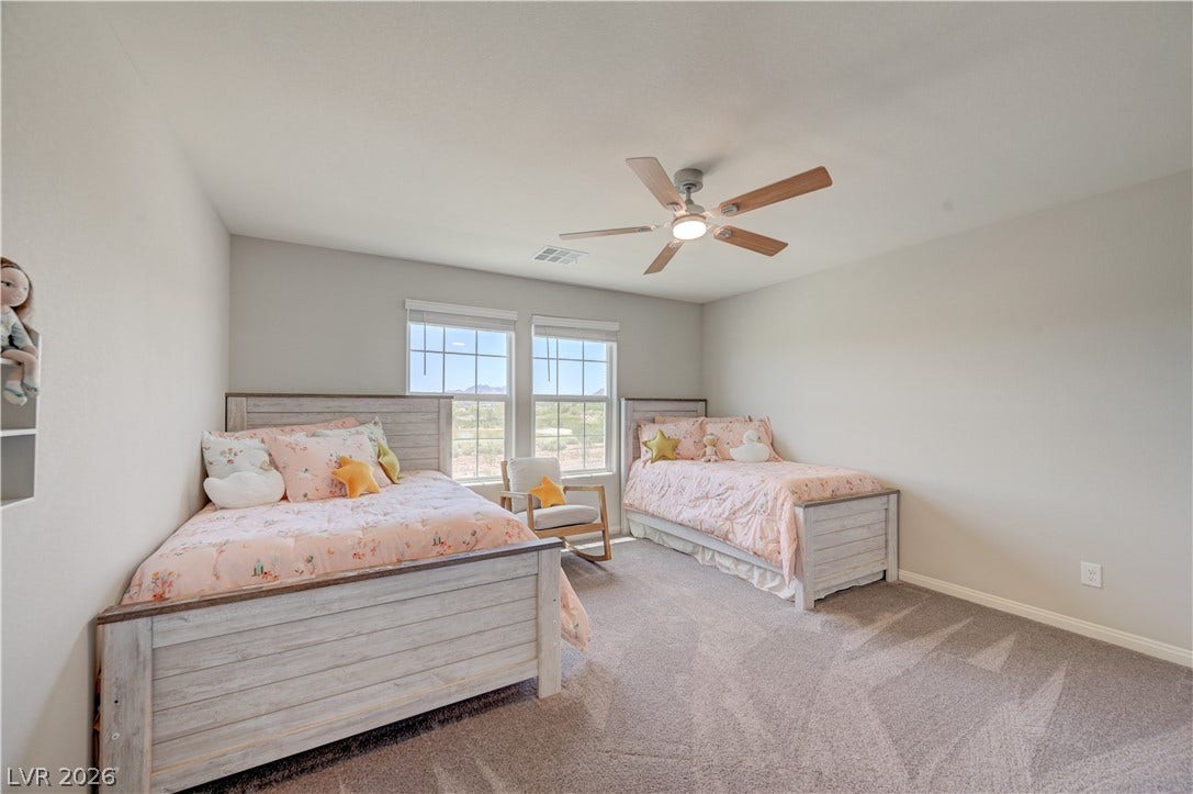 3rd bed has Two bright windows illuminate a cozy bedroom, featuring plush carpeting and a modern ceiling fan.