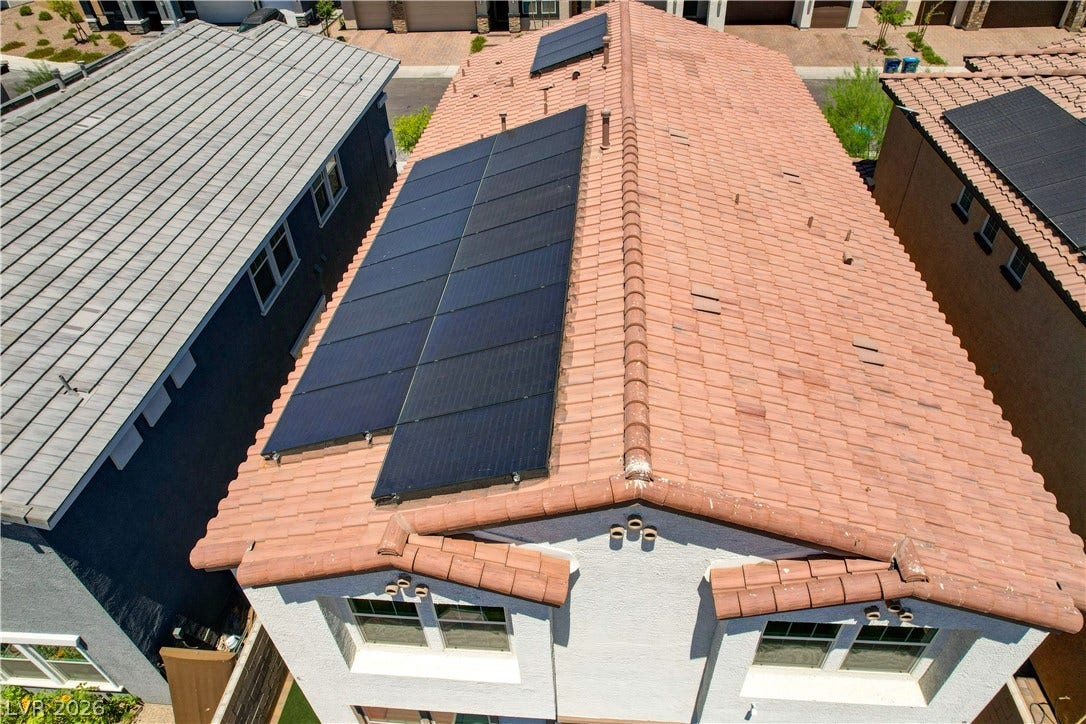 An aerial perspective showcases the home's tiled roof and modern solar panel installation.