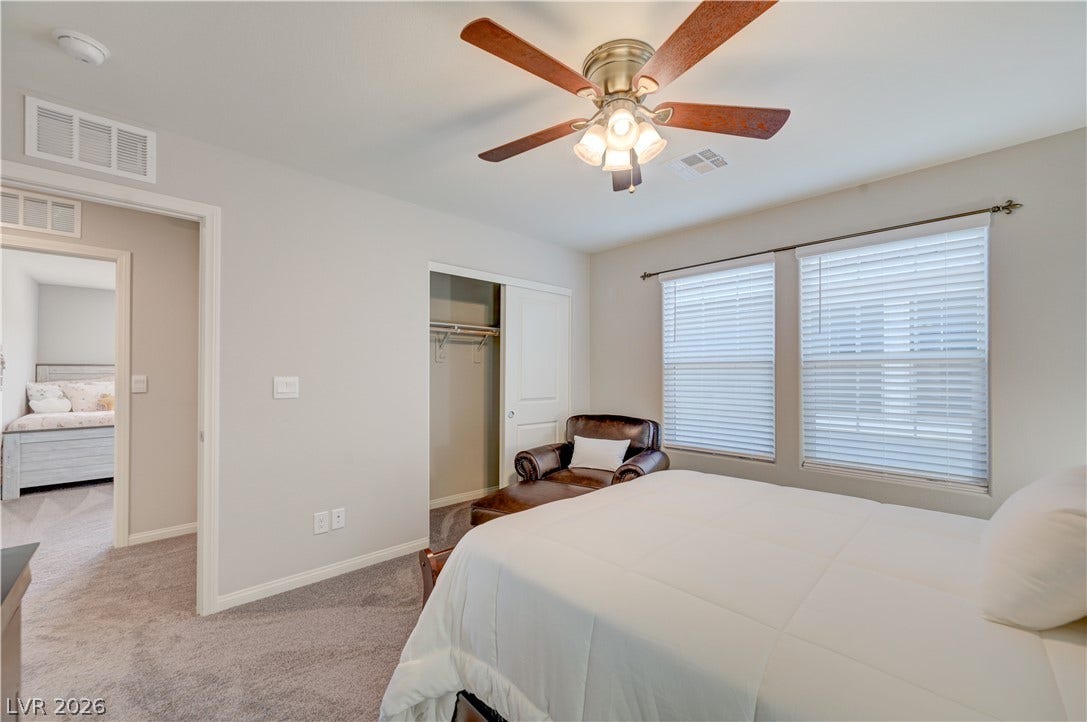 A well-lit 4th bedroom features plush carpeting and a convenient closet, providing a cozy and functional living space.