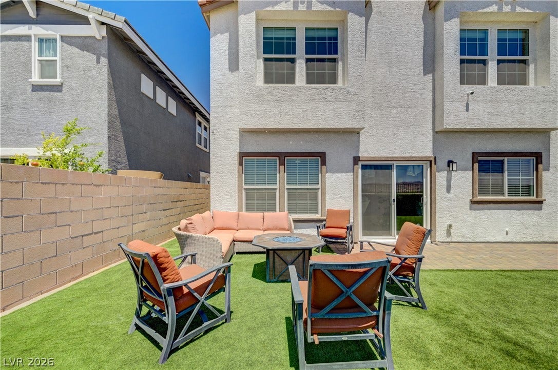 A spacious backyard patio area with artificial turf, ideal for outdoor entertaining.
