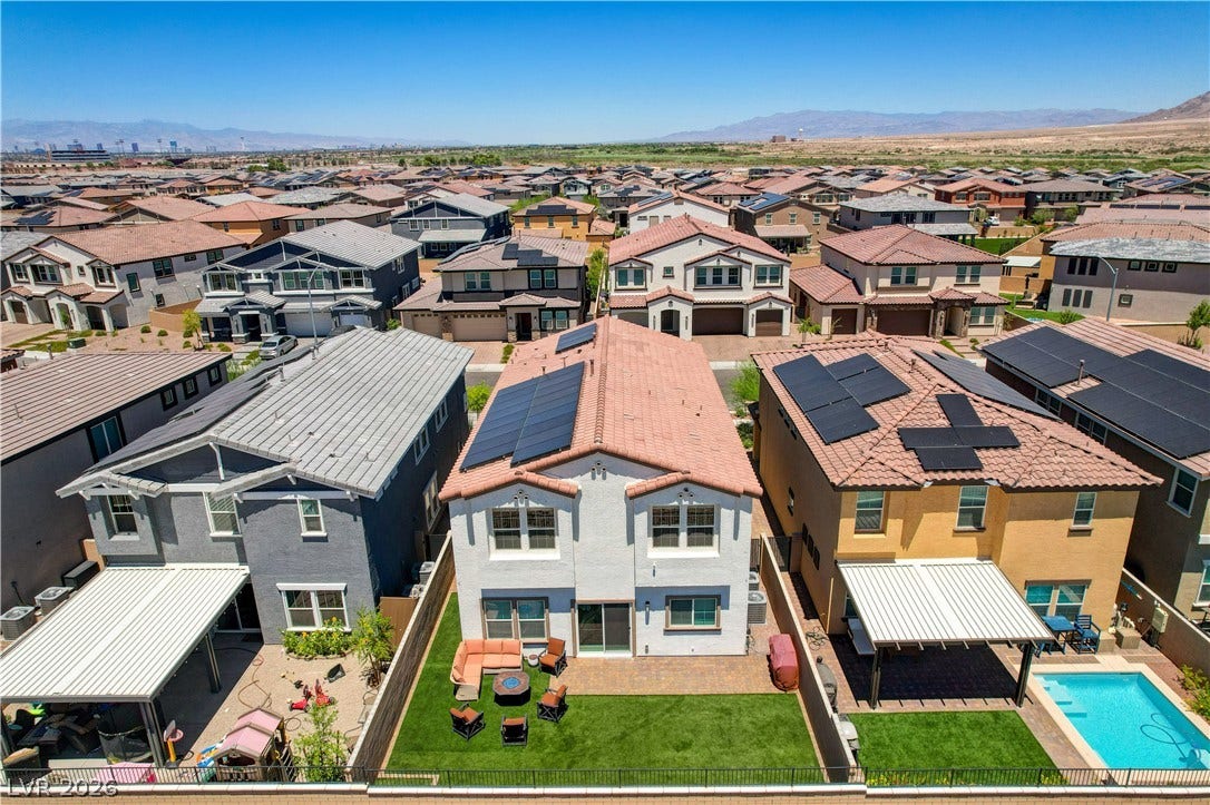 An aerial perspective reveals a vibrant neighborhood with individual backyard oases, featuring lush green spaces and private pools.