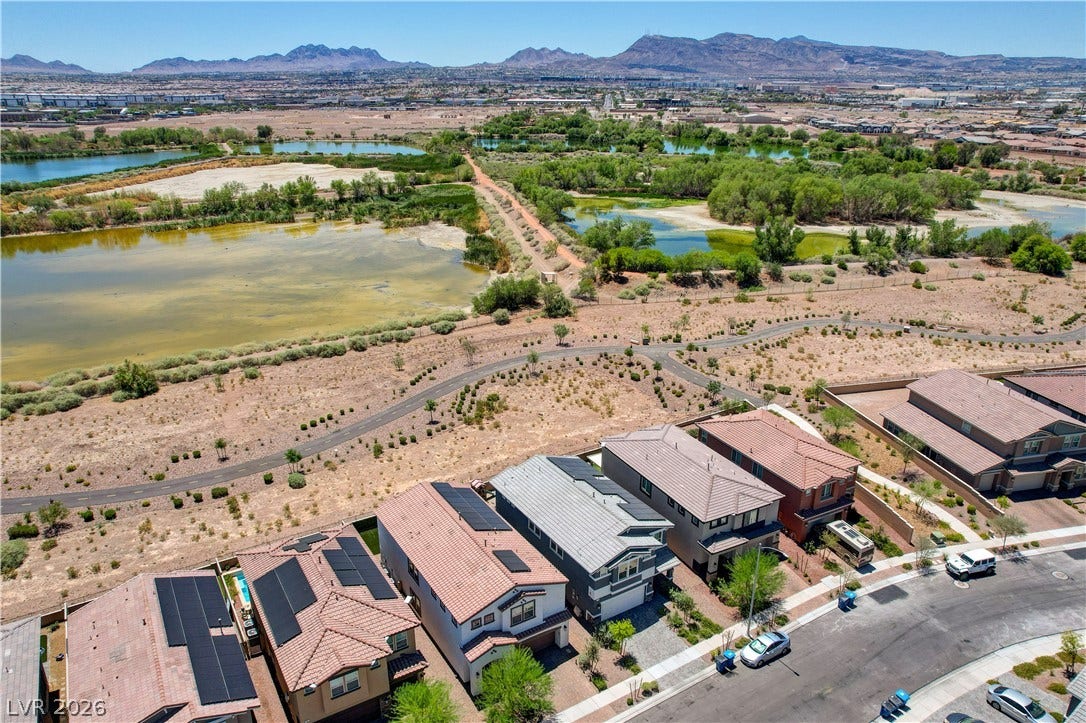 Aerial view captures contemporary homes nestled beside scenic natural bird preserve with mountain backdrops.