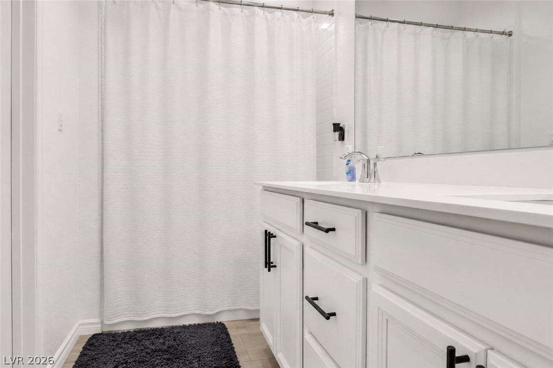 A well-appointed bath features a sleek vanity and a pristine shower.