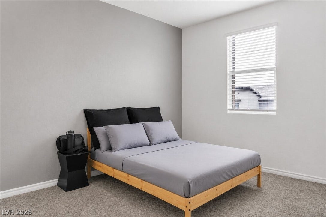 A well-lit bedroom provides a serene retreat with soft carpeting and ample natural light.