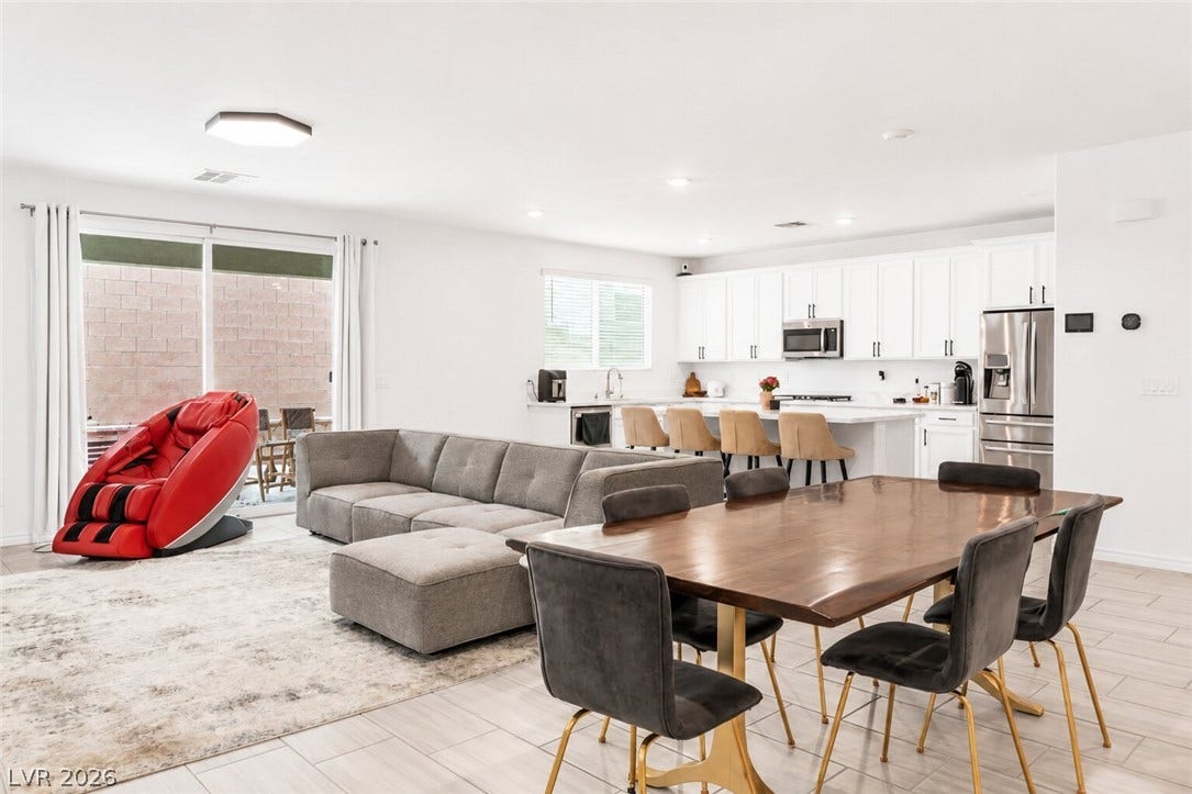 An open concept living area seamlessly blends a modern kitchen with a spacious dining and lounge zone, offering clean lines and natural illumination.