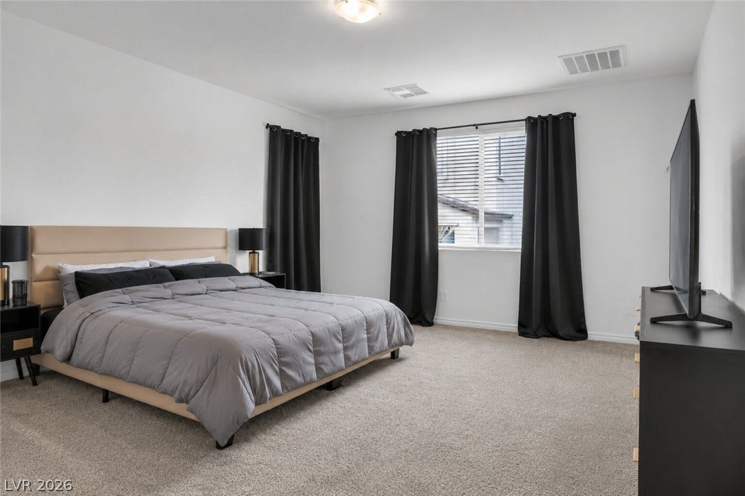 A quiet retreat, this bedroom offers ample space and plush carpeting for ultimate comfort.
