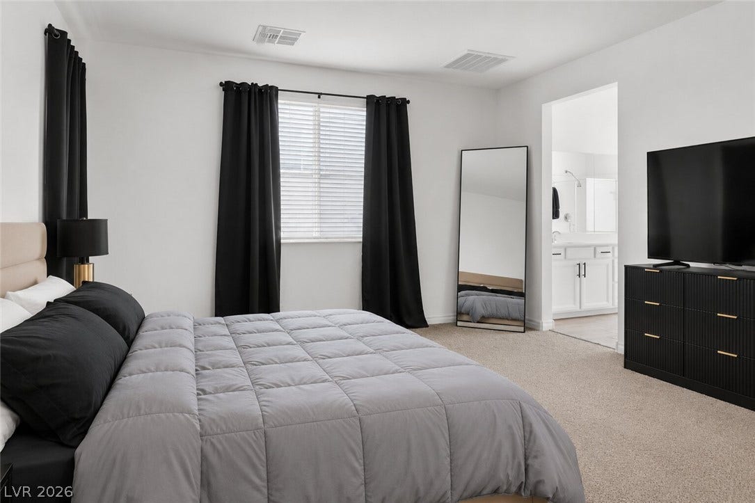 Well-lit sleeping quarters with plush carpeting and private access to an ensuite bath.
