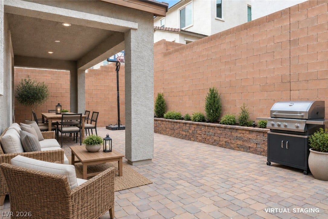 An inviting outdoor patio, perfect for entertaining, features a paved surface, a dining area, and a barbecue grill.