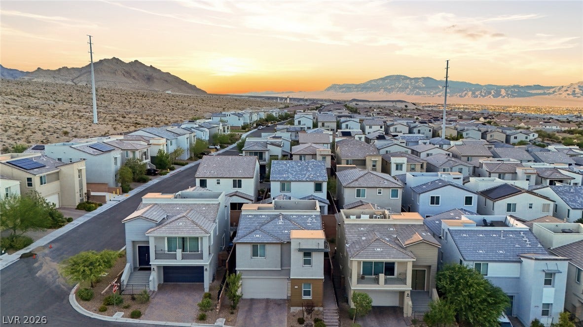 Nestled near towering mountain ranges, this peaceful suburban neighborhood enjoys scenic evening skies.