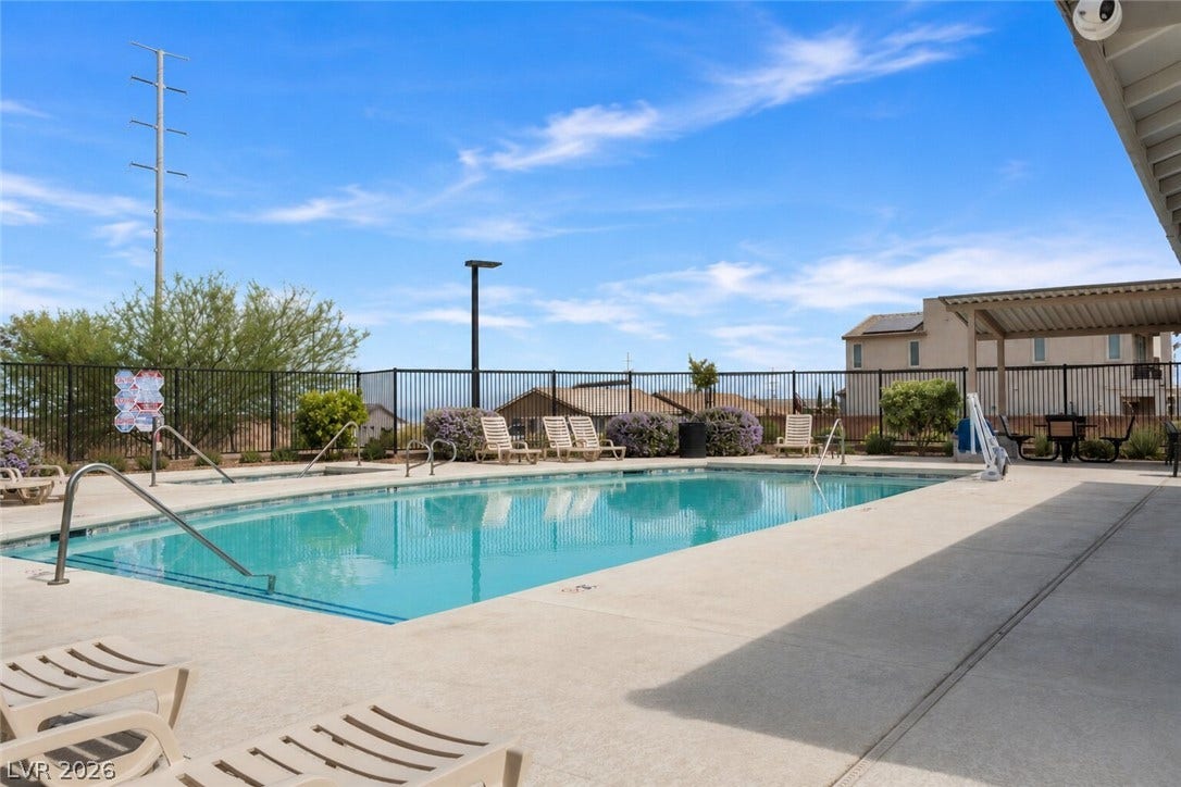 A refreshing swimming pool awaits, surrounded by a paved deck and lounge chairs for ultimate relaxation.