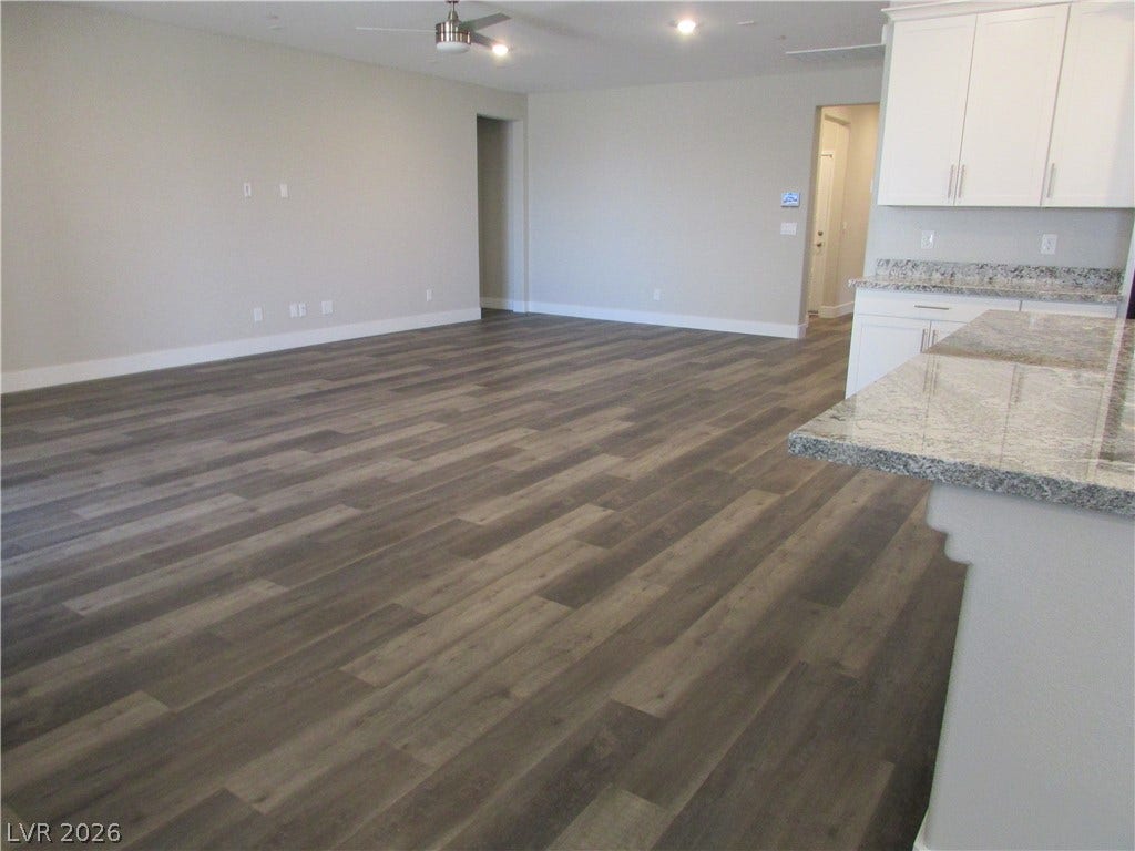 510 CHESTNUT FALCON AVE, Henderson, NV 89011 Laminate flooring connects an open-concept living area with a functional kitchen breakfast bar.