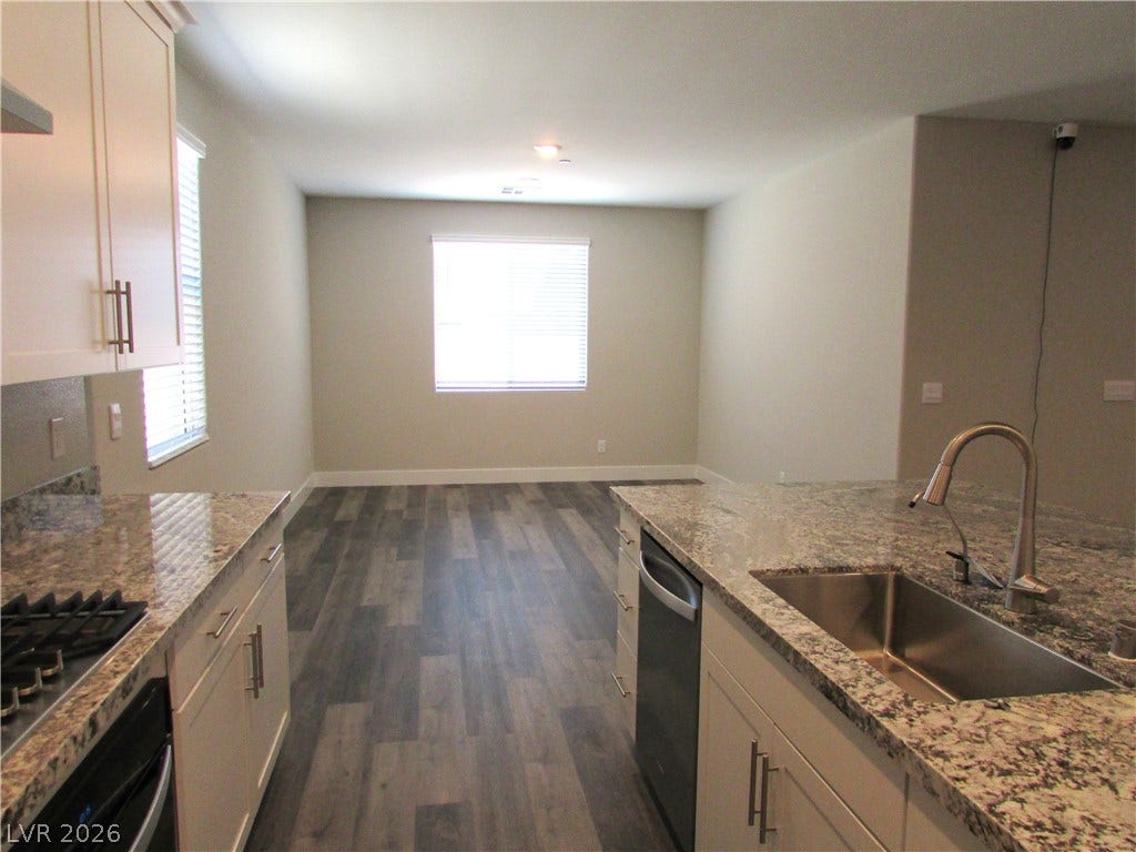 510 CHESTNUT FALCON AVE, Henderson, NV 89011 Granite counters and stainless steel appliances complete this contemporary kitchen, flowing into an adjacent living space.