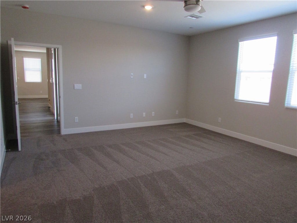 510 CHESTNUT FALCON AVE, Henderson, NV 89011 An airy bedroom with plush carpeting and natural light filtering through the windows.