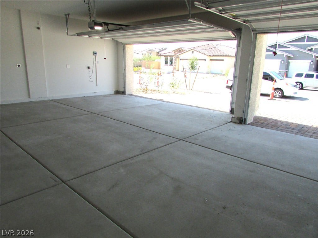 510 CHESTNUT FALCON AVE, Henderson, NV 89011 A spacious, clean garage with a concrete floor, ready for vehicles or projects. Photo is Actual Home.