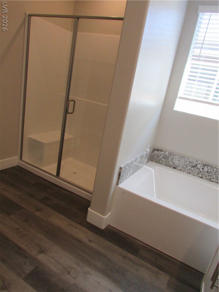 510 CHESTNUT FALCON AVE, Henderson, NV 89011 A well-lit bathroom features a spacious shower with granite accents and rich wood-toned flooring.